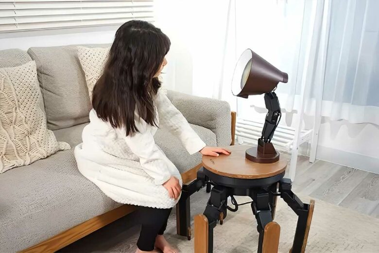Une petite fille interagit avec la lampe robot Mi-Mo.