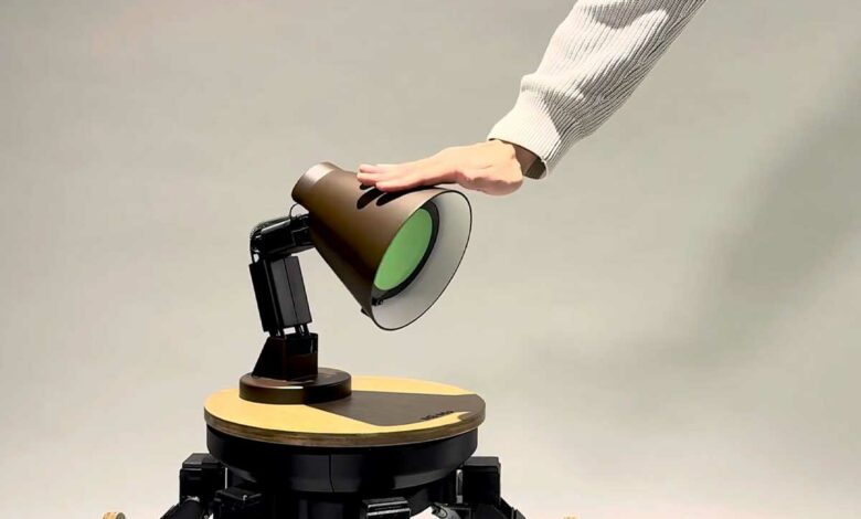 Un homme caresse une lampe robot.