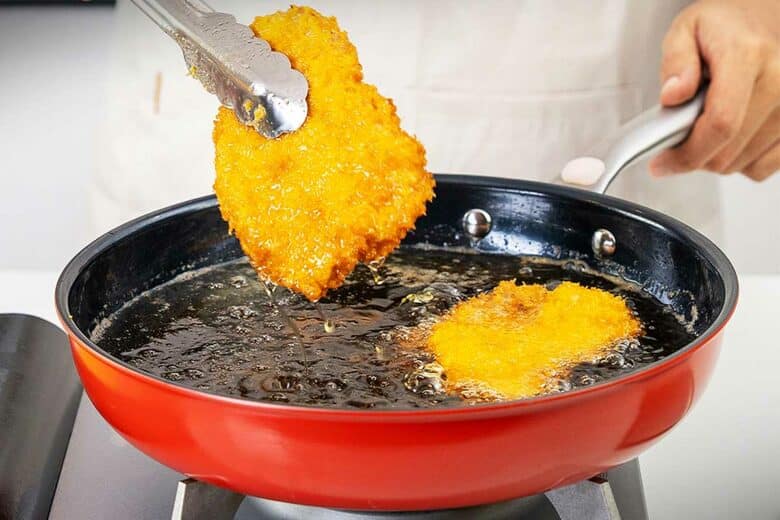Une personne cuisine dans une poêle en titane.