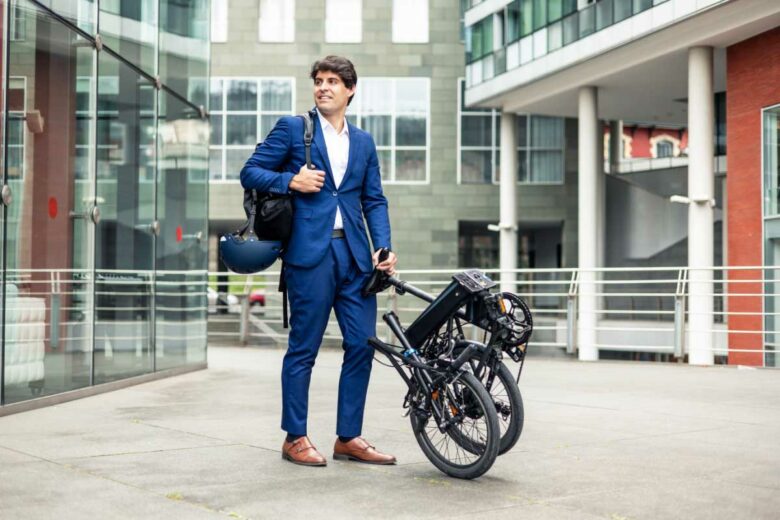 Un homme d'affaires avec un vélo pliant.