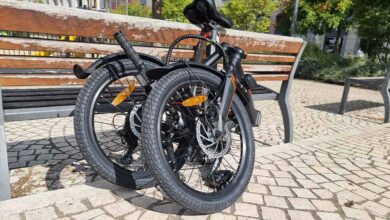 Un vélo pliant contre un banc.