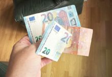 Une personne tient des billets dans la main.