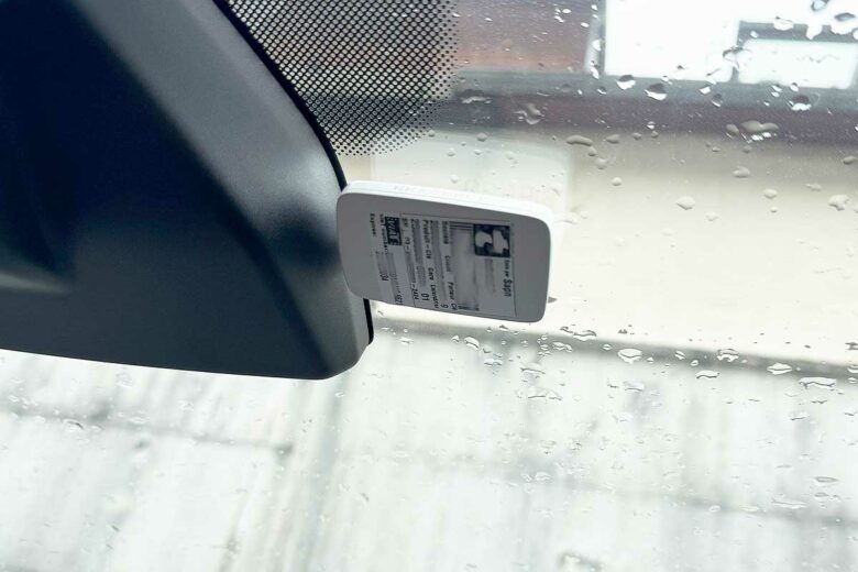 Un badge de télépéage installé derrière le pare-brise.