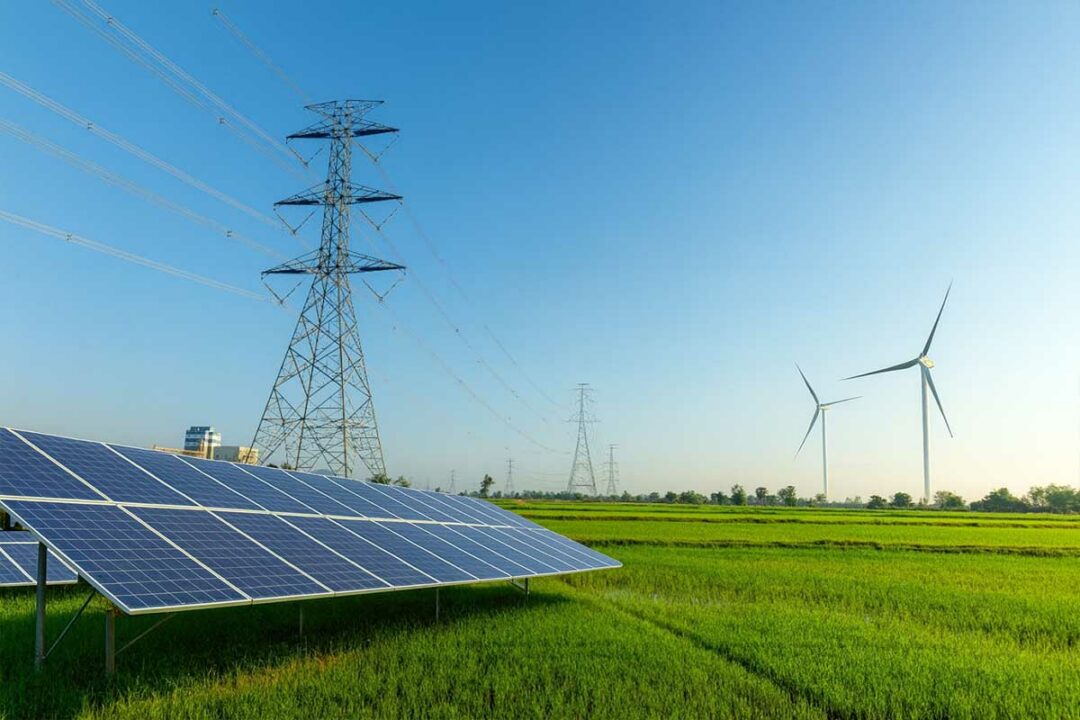 Une étendue avec un pylône électrique, des panneaux solaires et des éoliennes.