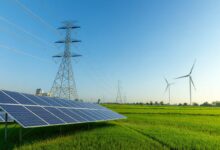 Une étendue avec un pylône électrique, des panneaux solaires et des éoliennes.