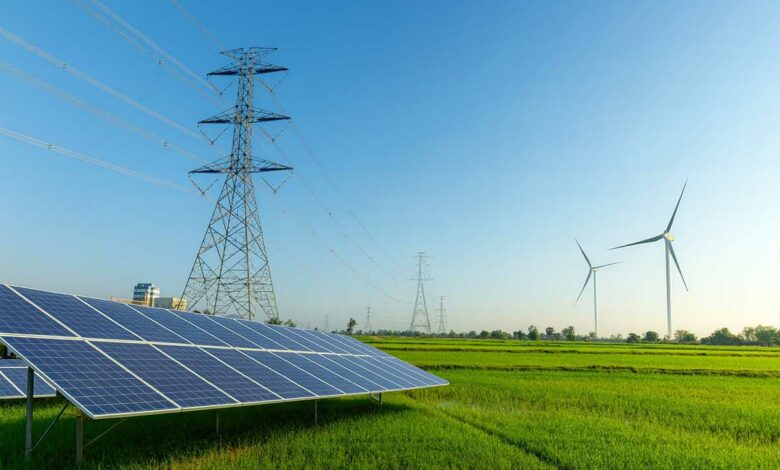 Une étendue avec un pylône électrique, des panneaux solaires et des éoliennes.