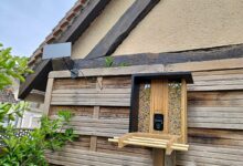 Installation extérieure réussie : la mangeoire connectée Birdfy en bambou fixée au jardin avec son panneau solaire orienté plein sud.