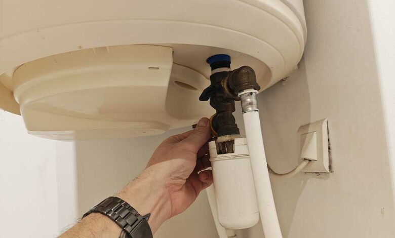 Une personne vérifie son chauffe-eau.