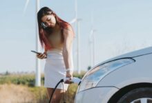 Une femme recharge son véhicule.