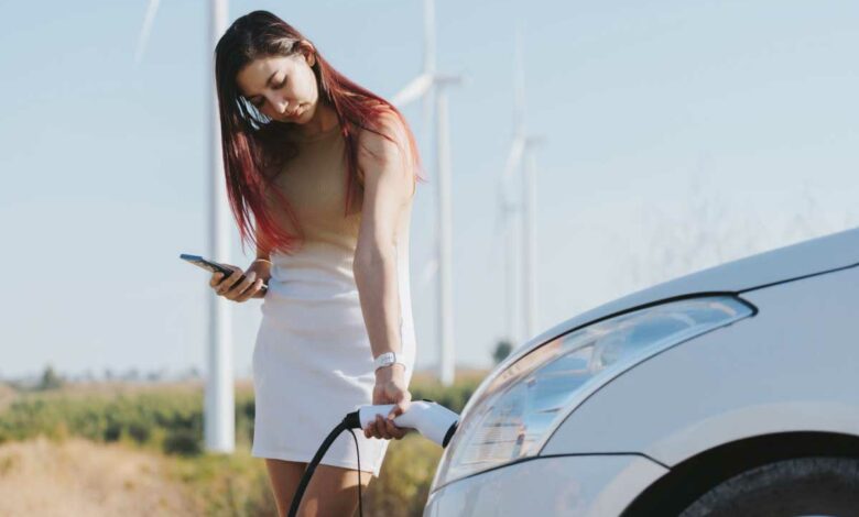 Une femme recharge son véhicule.