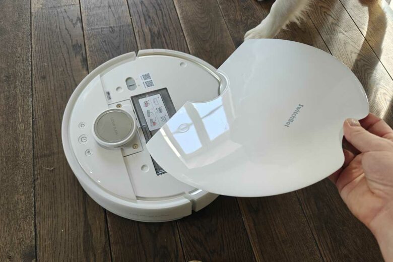 Un aspirateur robot en blanc nacré.