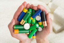 Des mains tiennent des piles au-dessus de sucre.