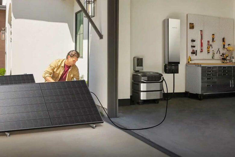 Un homme branche des panneaux solaires à son système de stockage.
