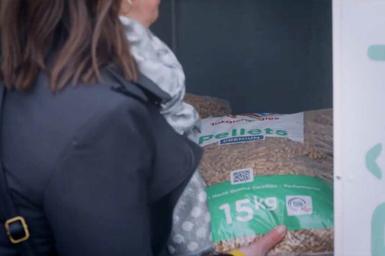Une femme se sert dans un distributeur de pellets.
