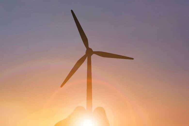 Une éolienne en contrejour au coucher de soleil.