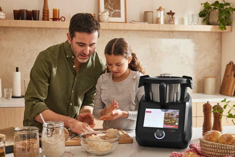 Un père et sa fille cuisinent ensemble avec un robot Monsieur Cuisine.