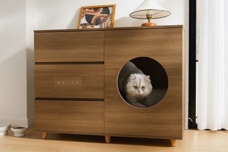 Un chat sort de son meuble litière.