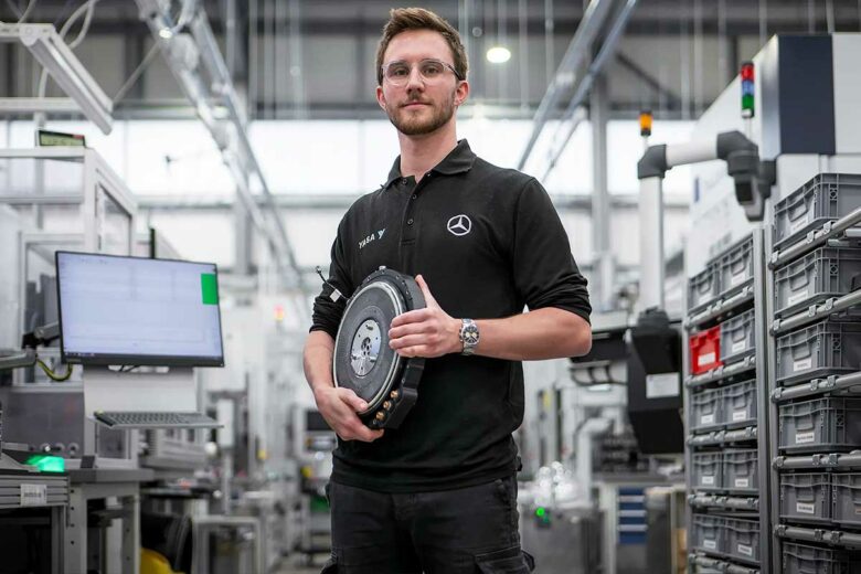 Un homme avec un moteur YASA dans les mains.