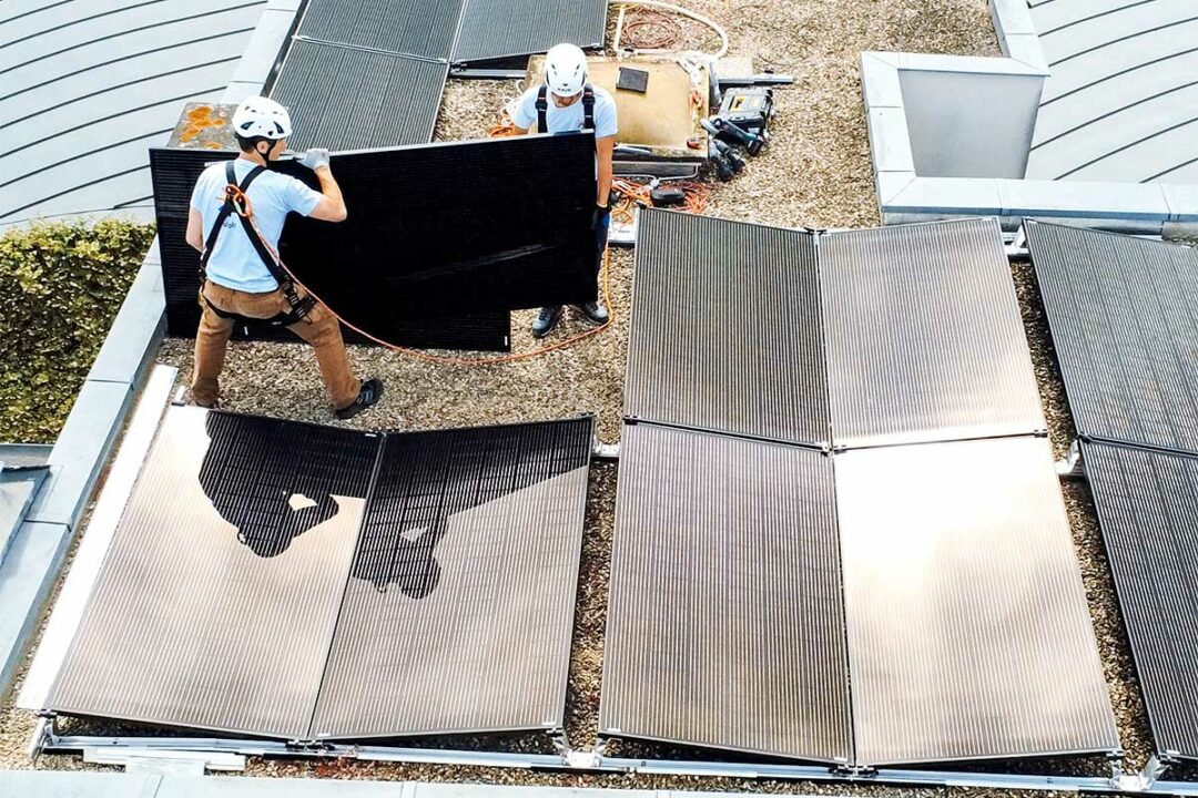 Des installateurs de panneaux solaire sur un toit.