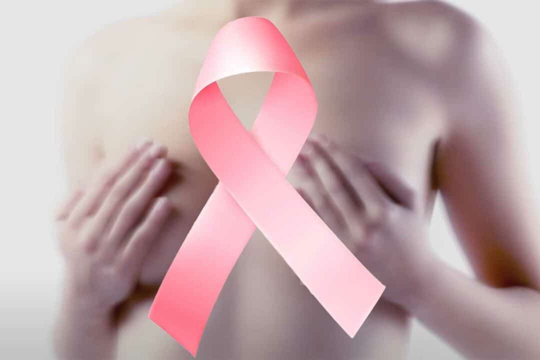 Une femme les mains sur sa poitrine et un ruban rose.