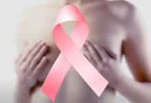 Une femme les mains sur sa poitrine et un ruban rose.