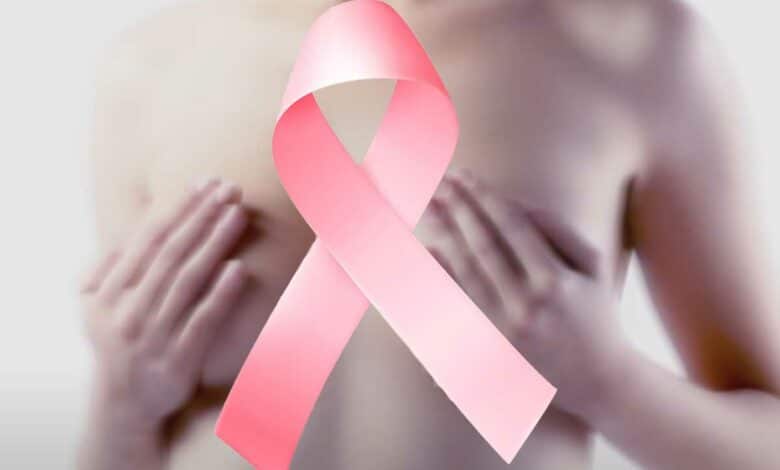 Une femme les mains sur sa poitrine et un ruban rose.
