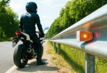 Un motard proche d'une glissière de sécurité.