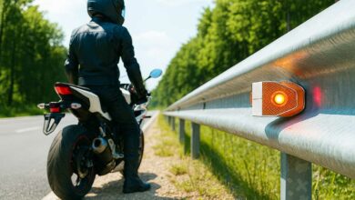 Un motard proche d'une glissière de sécurité.