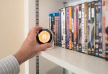 Une personne ajuste son chauffage avec un thermostat connecté.
