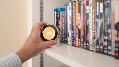 Une personne ajuste son chauffage avec un thermostat connecté.
