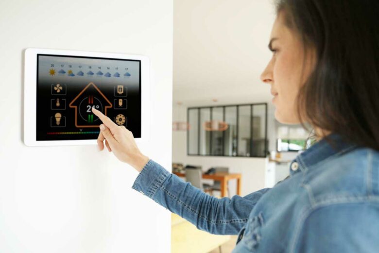 Une femme ajuste le chauffage de son logement.