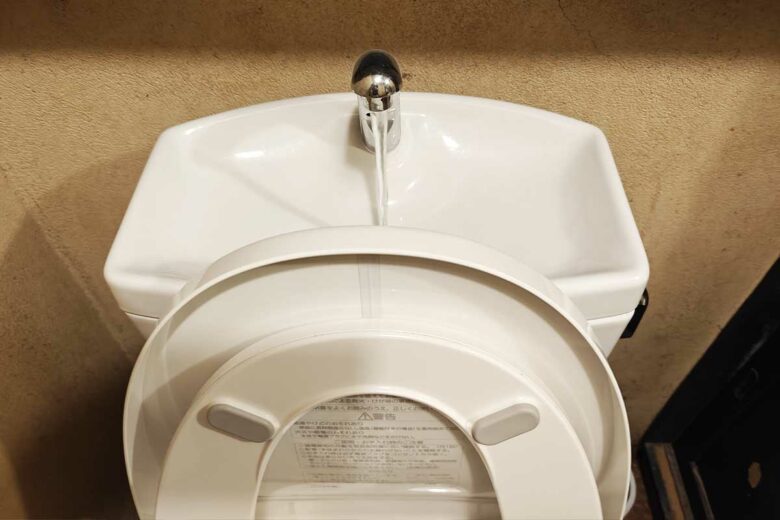 Un WC japonais avec un robinet intégré pour se laver les mains et réutiliser les eaux grises dans la chasse.