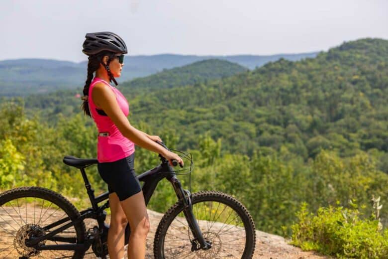 Une femme à coté de son vélo électrique.