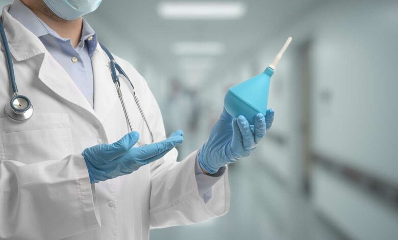 Un médecin avec une poire de lavement.