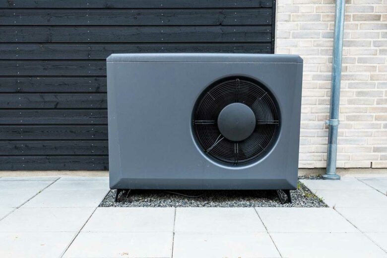 Une pompe à chaleur installée devant une maison.