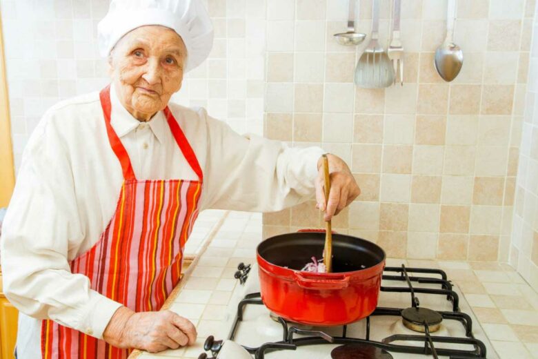 Une personne agée fait la cuisine.