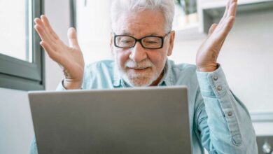 Un homme agé devant son ordinateur.