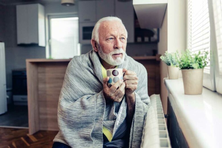 Une personne qui a froid avec une boisson chaude.