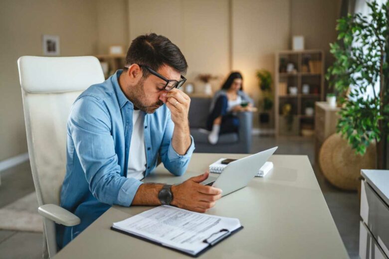 Un homme fatigué devant son ordinateur.
