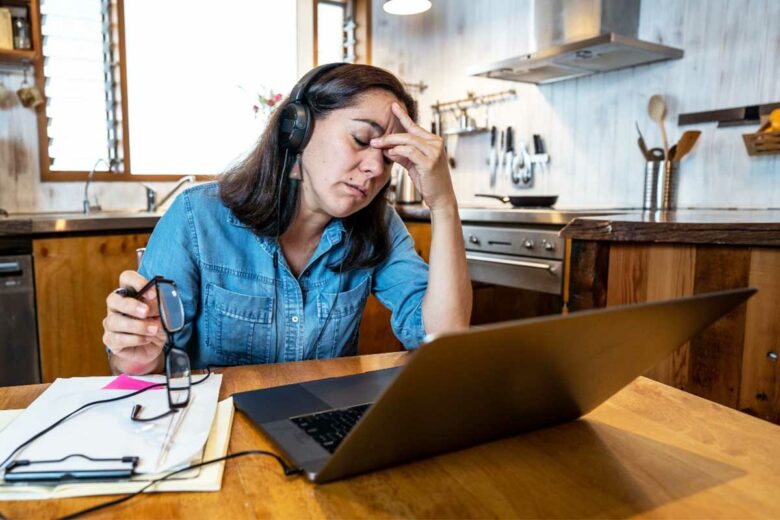 Une femme épuisée devant son ordinateur.