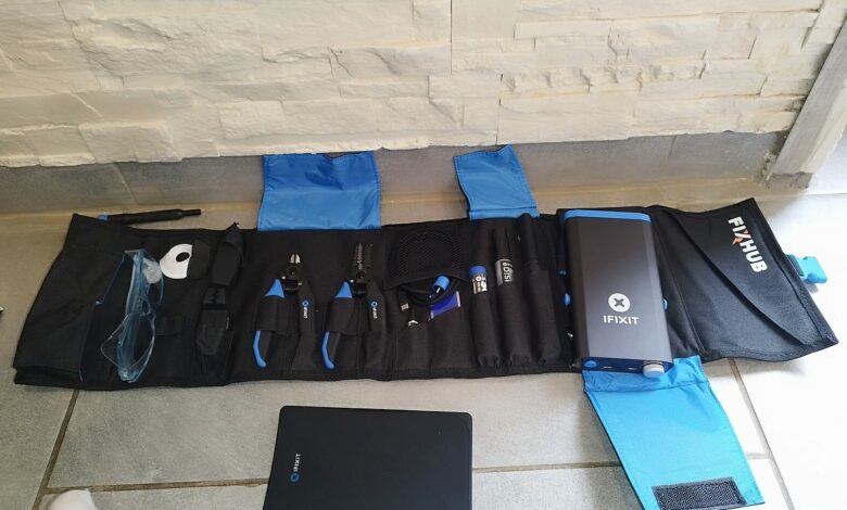 Détail des outils inclus dans le kit FixHub d’iFixit : pinces, câble USB-C et accessoires bien organisés.