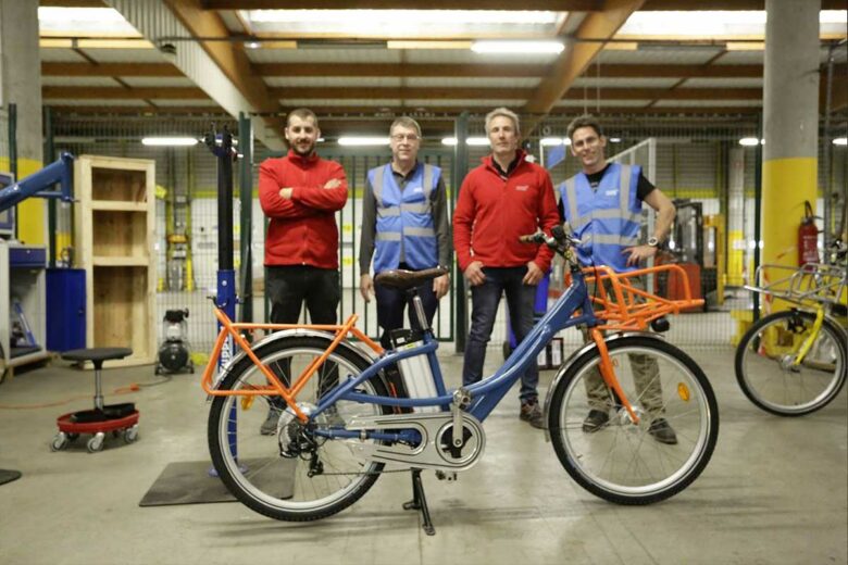 Une équipe de Nouvelle Attitude et un vélo électrique de La Poste remis en état.