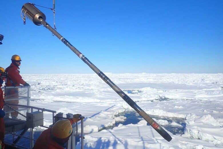 Des scientifiques avec un outil de carottage.