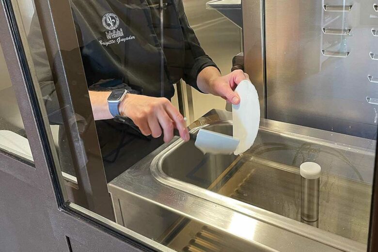 La cheffe prépare ses confections dans sa cuisine.