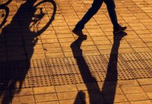 Un piéton et un cycliste partagent le trottoir.