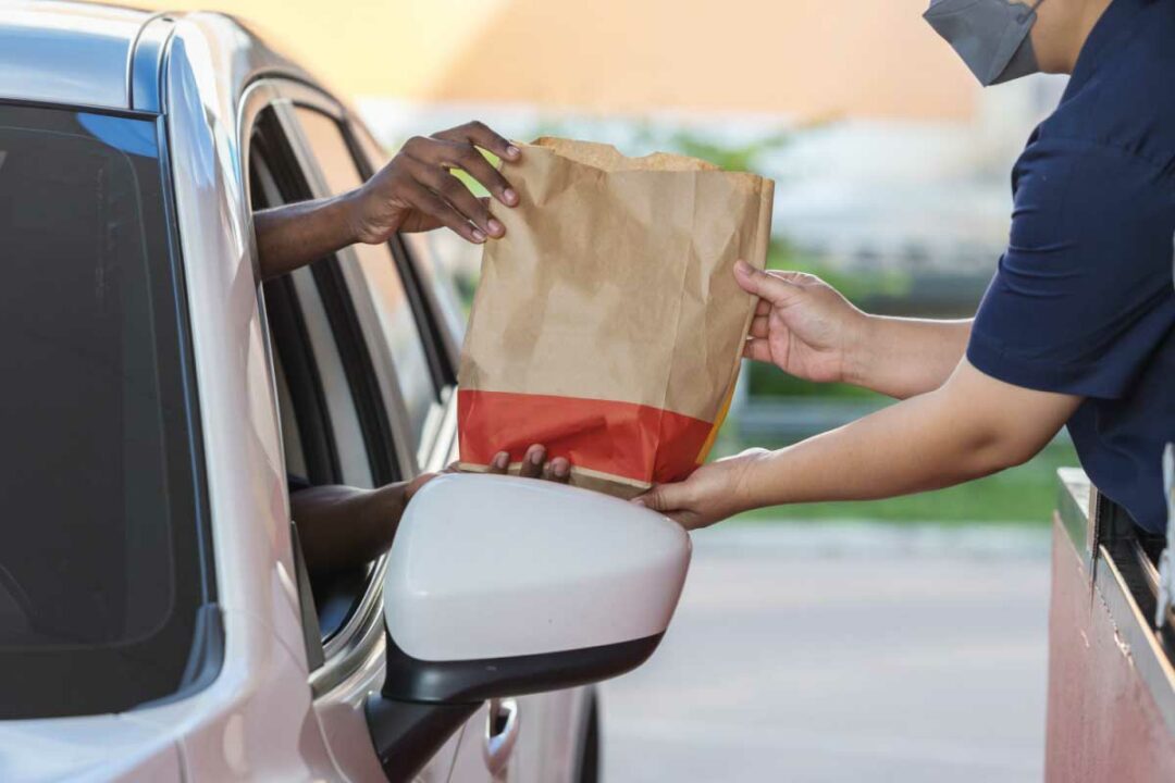 Une personne récupère sa commande au drive.