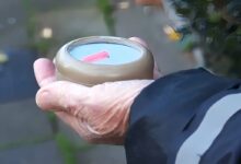 Un homme tient The Compass dans sa main.