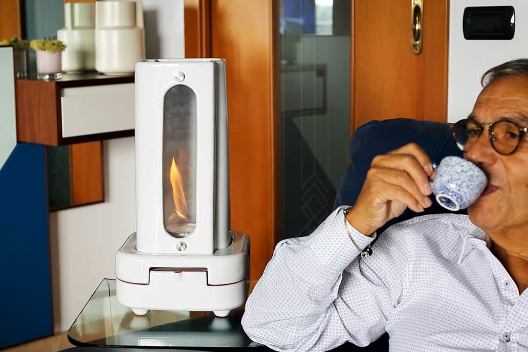 Un homme boit son café auprès de son chauffage d'appoint Tornado.