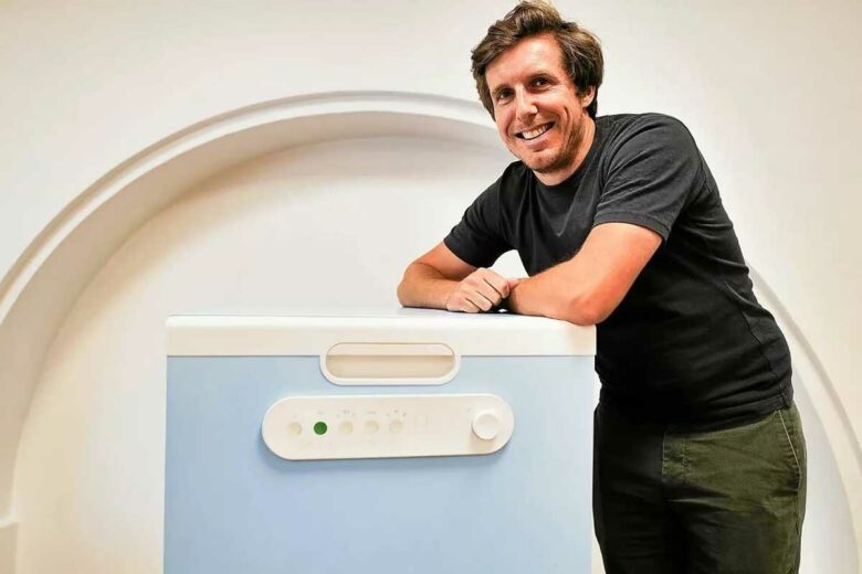 Un homme accoudé à un lave-vaisselle.