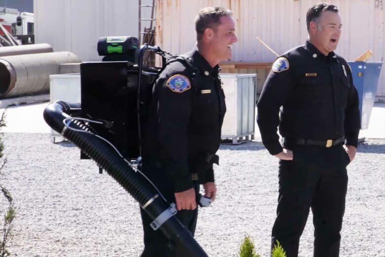 Un homme porte le dispositif anti-incendie comme un sac à dos.